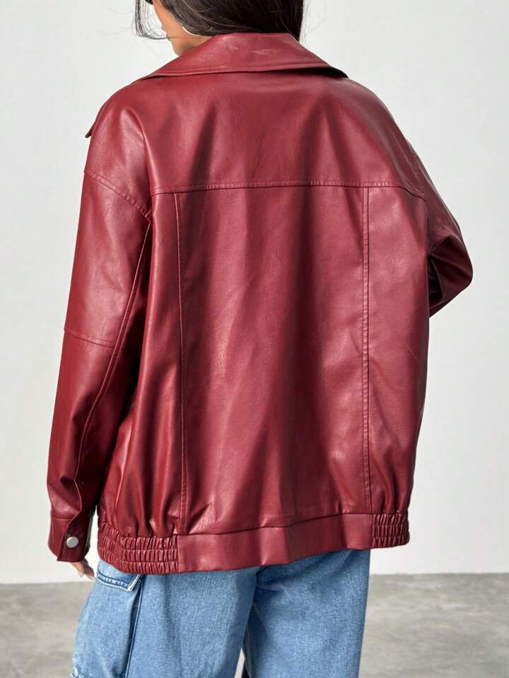 Person wearing a red leather jacket and blue jeans against a white background