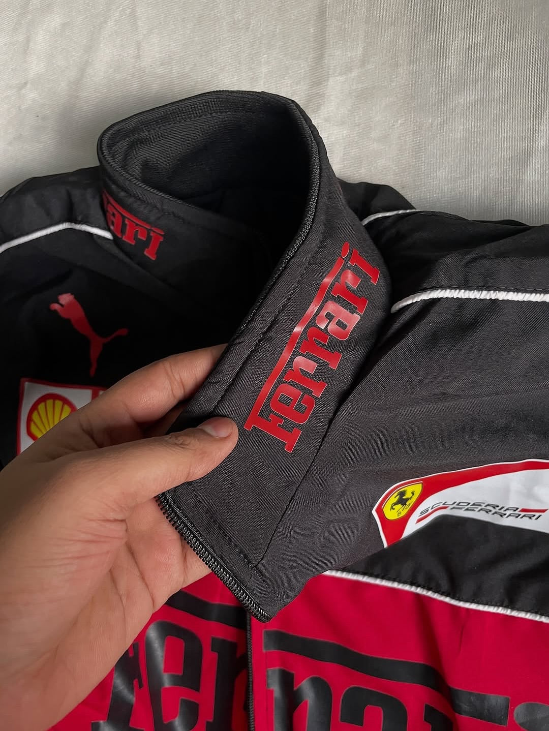 Close-up of a Ferrari jacket with visible branding on a gray background