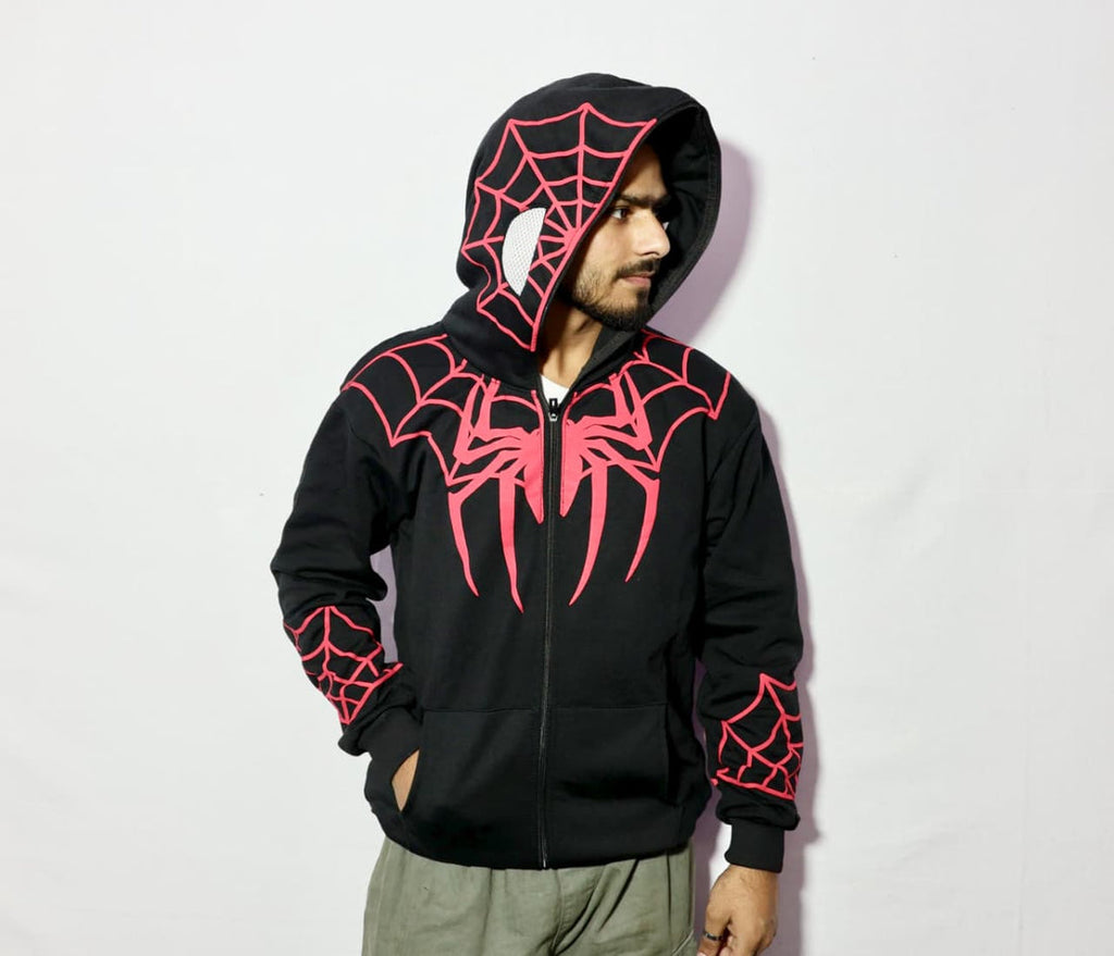 Person wearing a black hoodie with red spider web designs on a light gray background