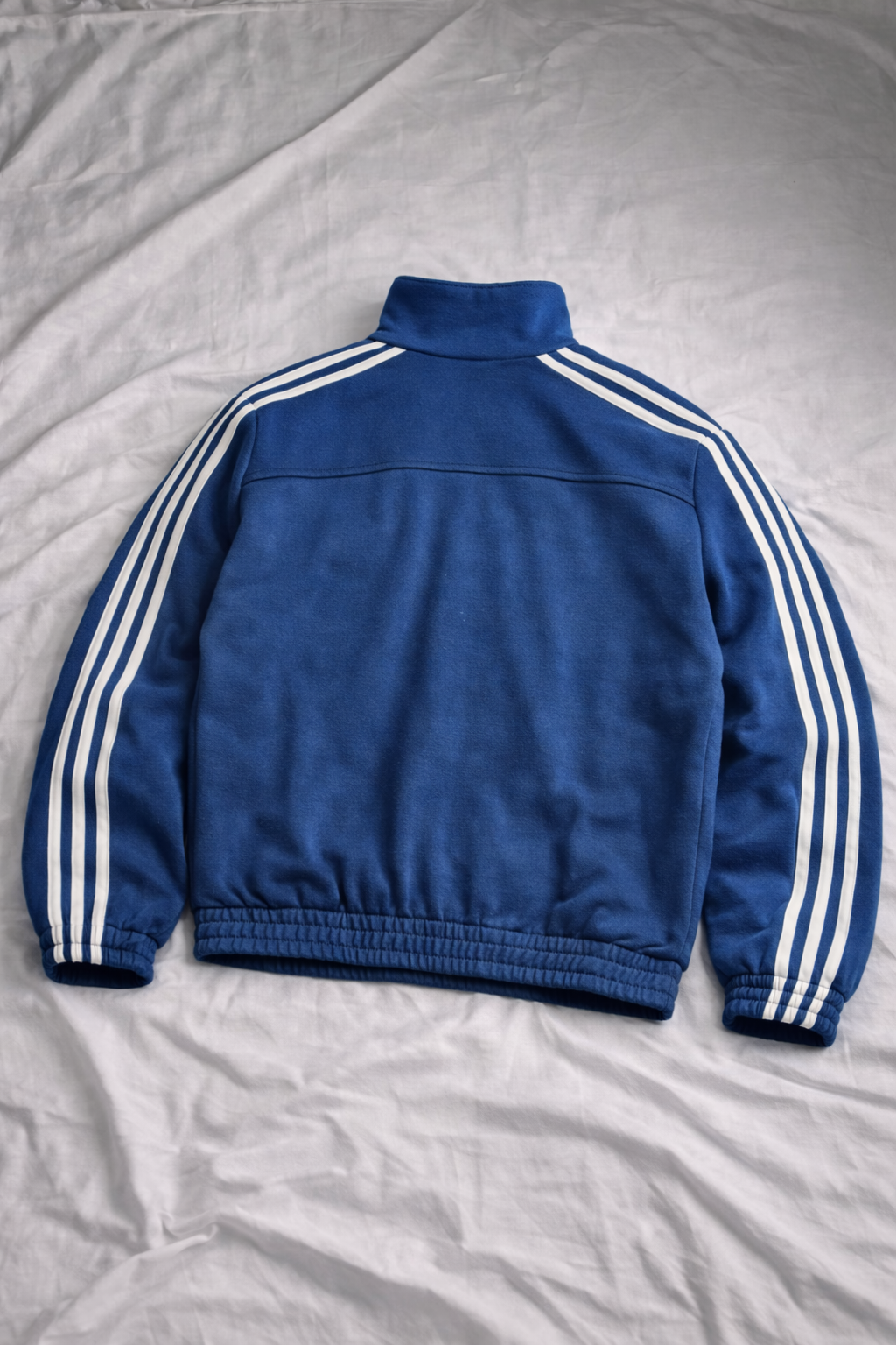 Blue jacket with white stripes on a gray surface