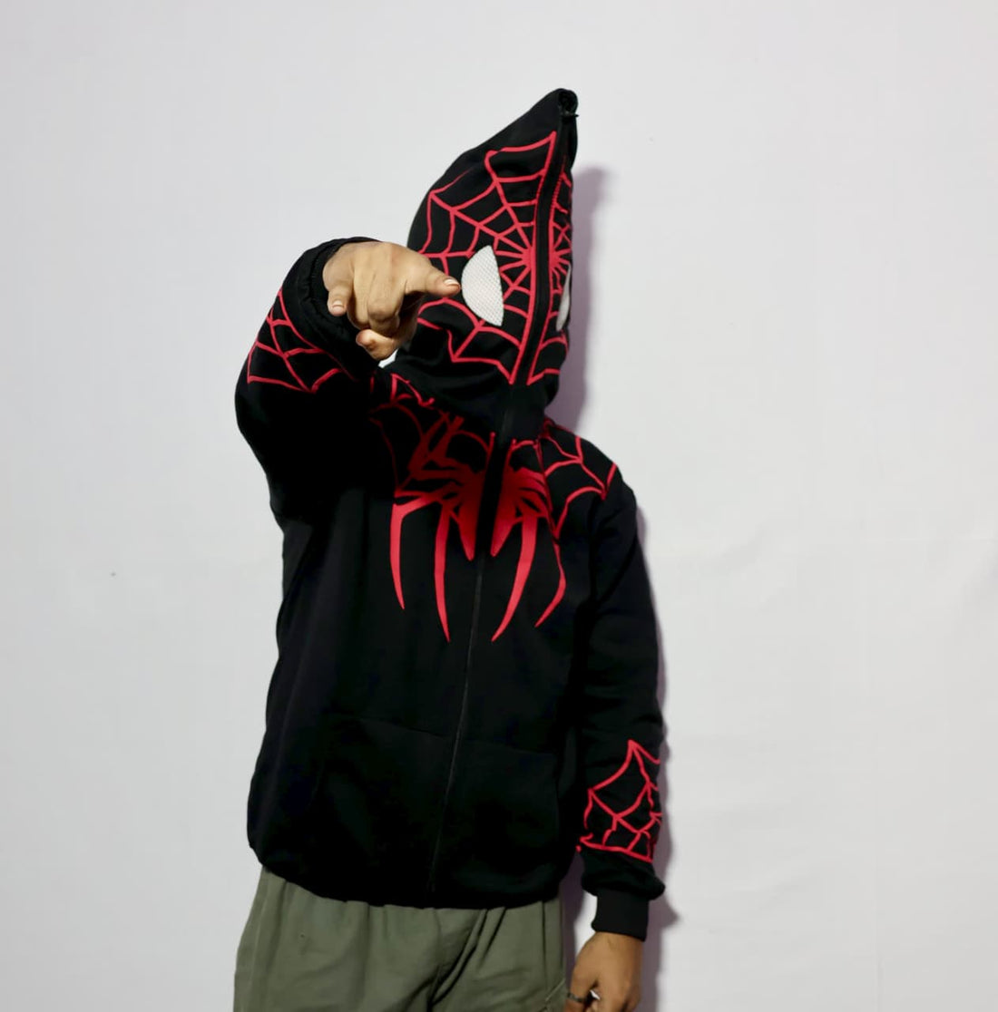 Black hoodie with red spider web design on a plain background