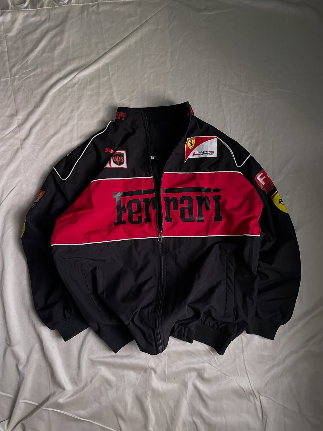 Black and red Ferrari jacket on a light gray background