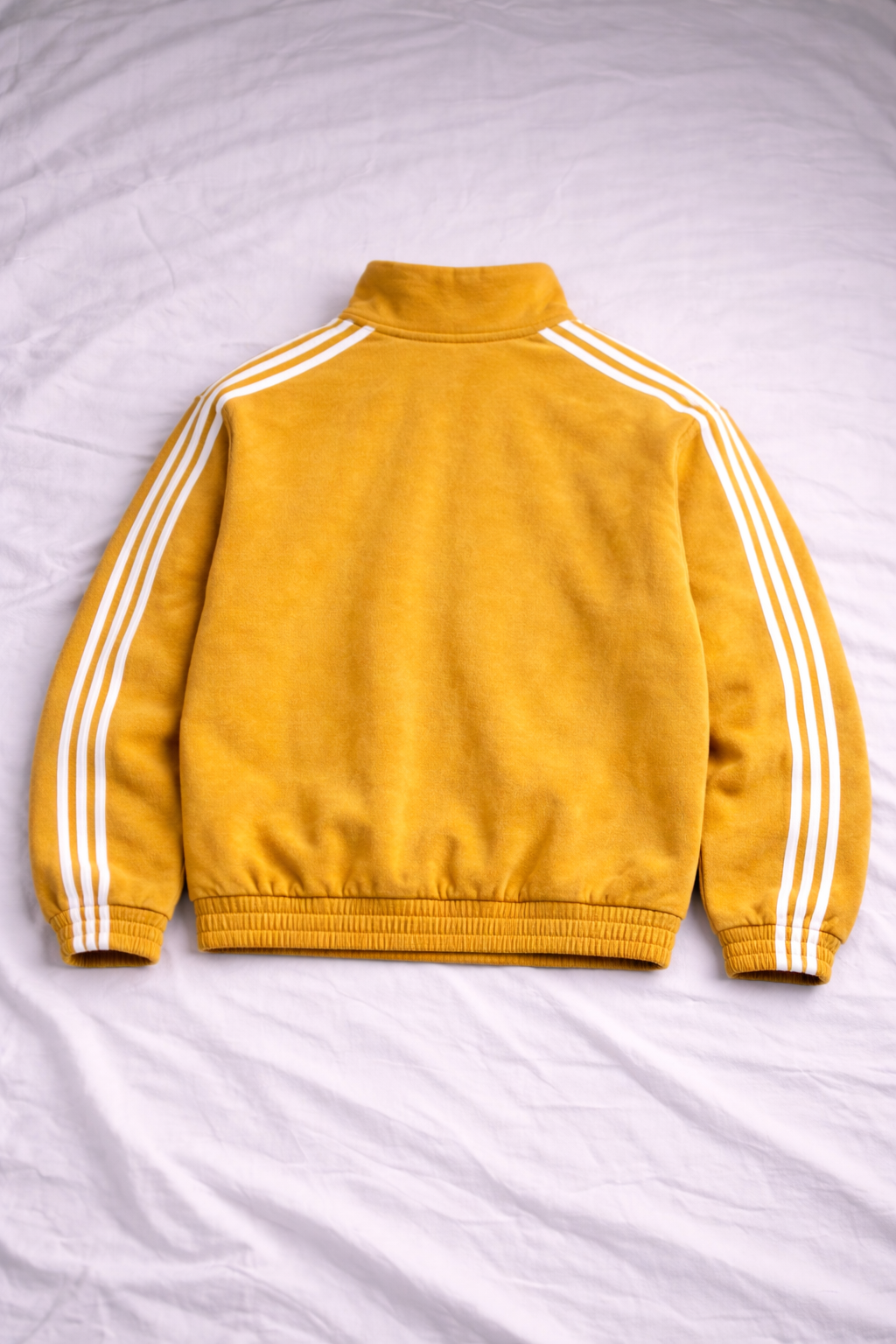 Yellow jacket with white stripes on a light gray background