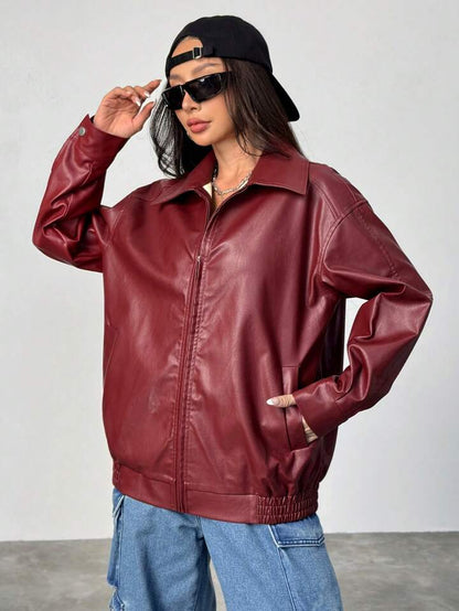 Person wearing a red leather jacket and black cap against a white background