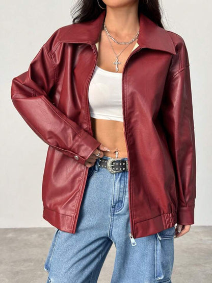 Person wearing a red leather jacket, white crop top, and blue jeans on a plain background