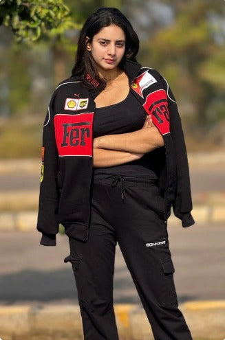 Woman wearing a black jacket with red and white logos outdoors